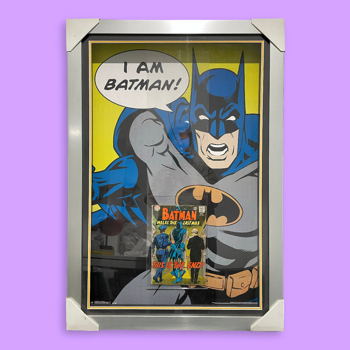 Framed poster of Batman with a comic book underneath