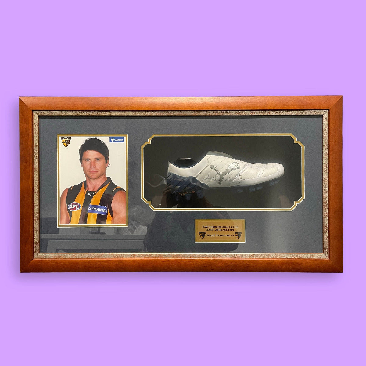 Framed sports boot and portrait on a purple background