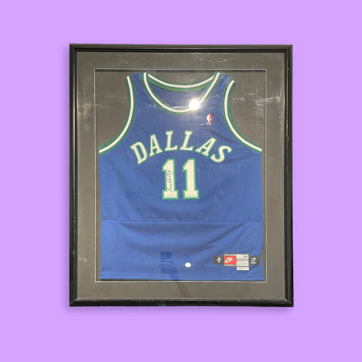 Framed blue basketball jersey with 'Dallas' and number '11' on a purple background