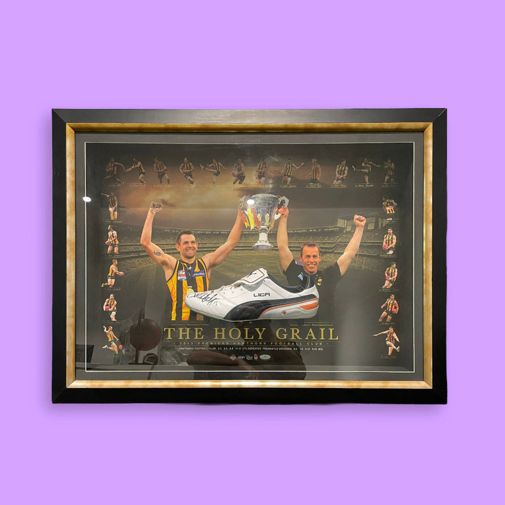 Framed poster with two people holding a trophy and a shoe, titled 'The Holy Grail', on a purple background.